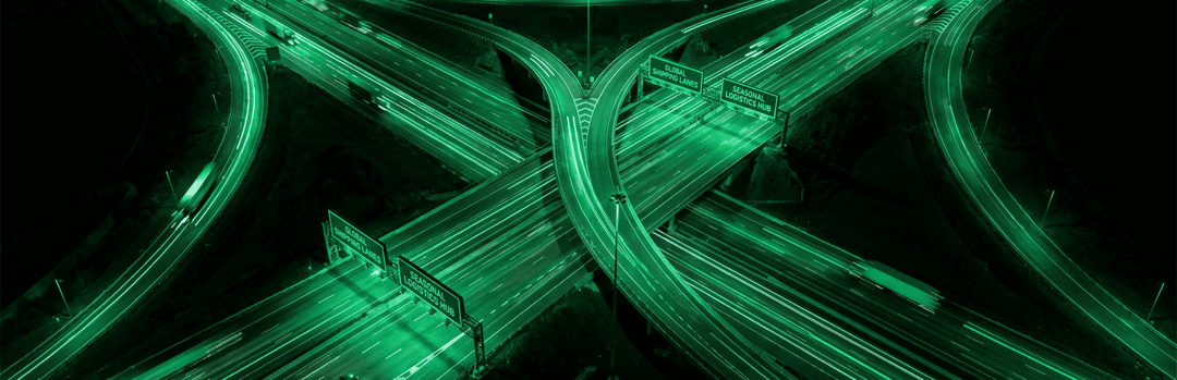 Glowing green highway interchange seen from above at night, showing busy seasonal shipping routes