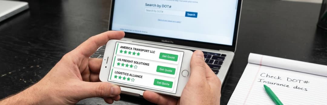 Hands holding a phone comparing rated car shipping companies in front of a laptop and a handwritten checklist